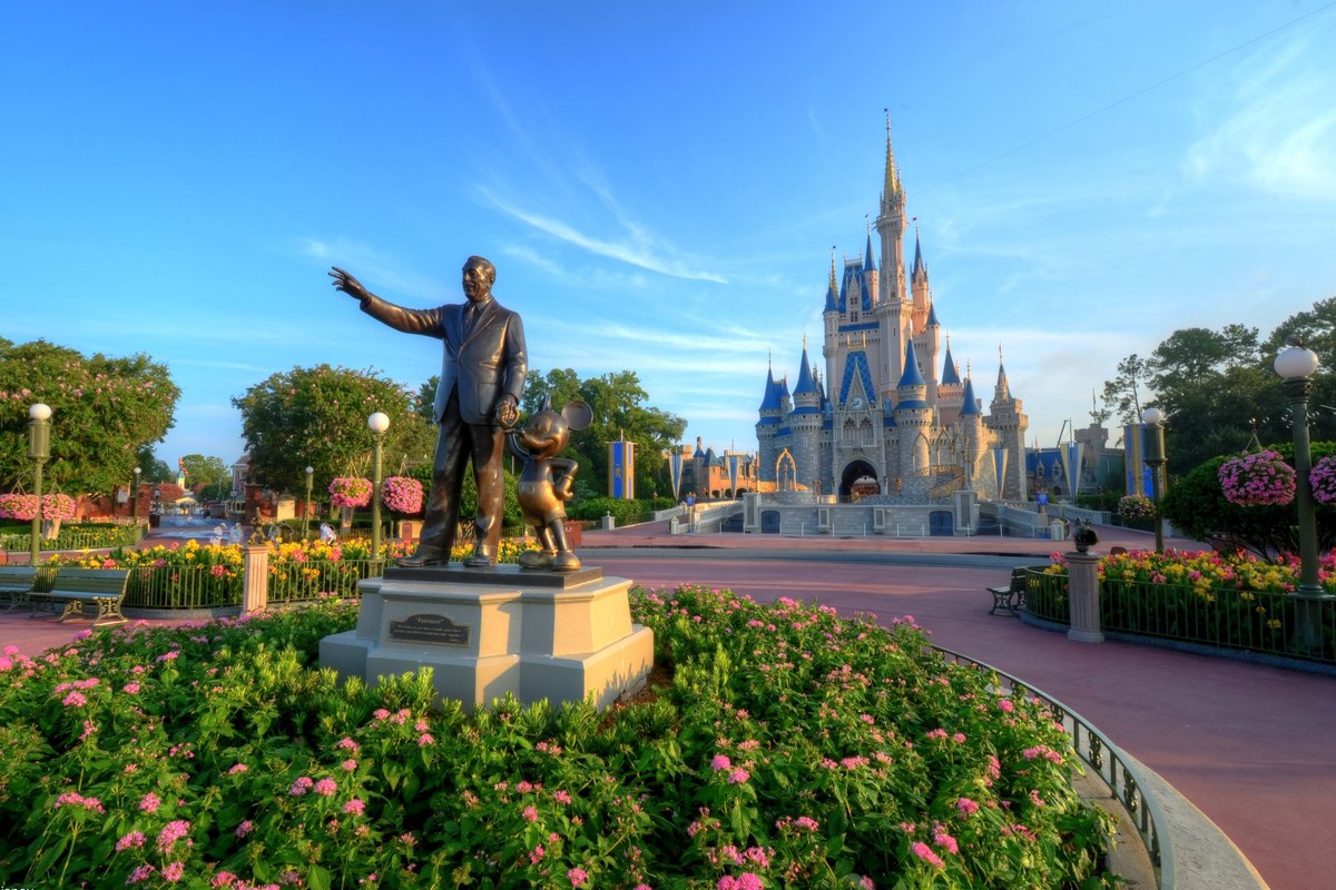 Fairytale castle behind a bronze statue at a Florida theme park
