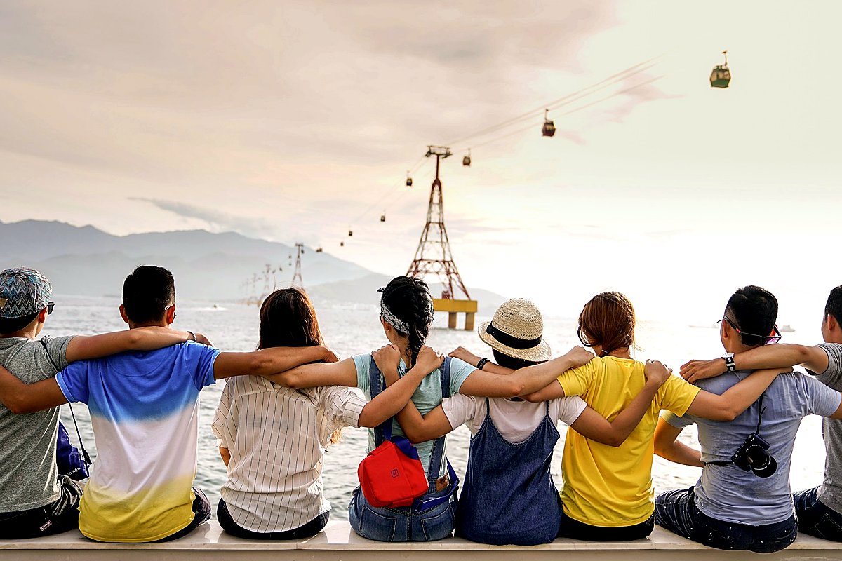 Friends sitting together overlooking water and mountains
